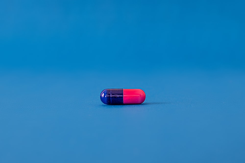 Píldora roja y azul sobre superficie azul