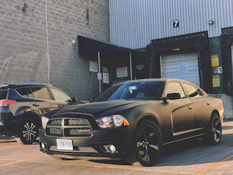 Side profile of a Dodge Charger with sleek side skirts and fender flares against an industrial backdrop at dusk