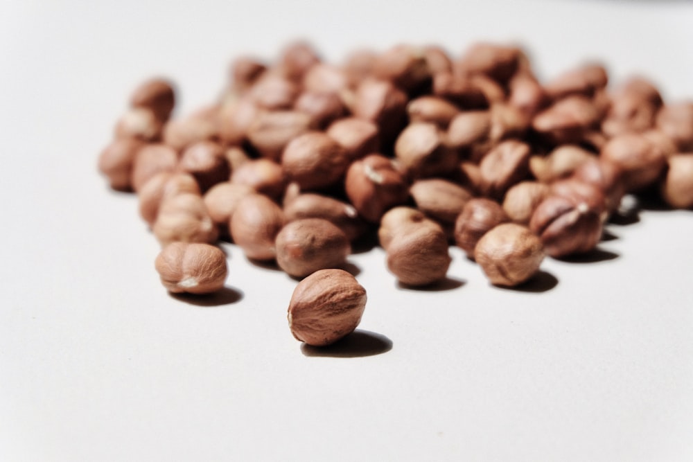 brown coffee beans on white surface