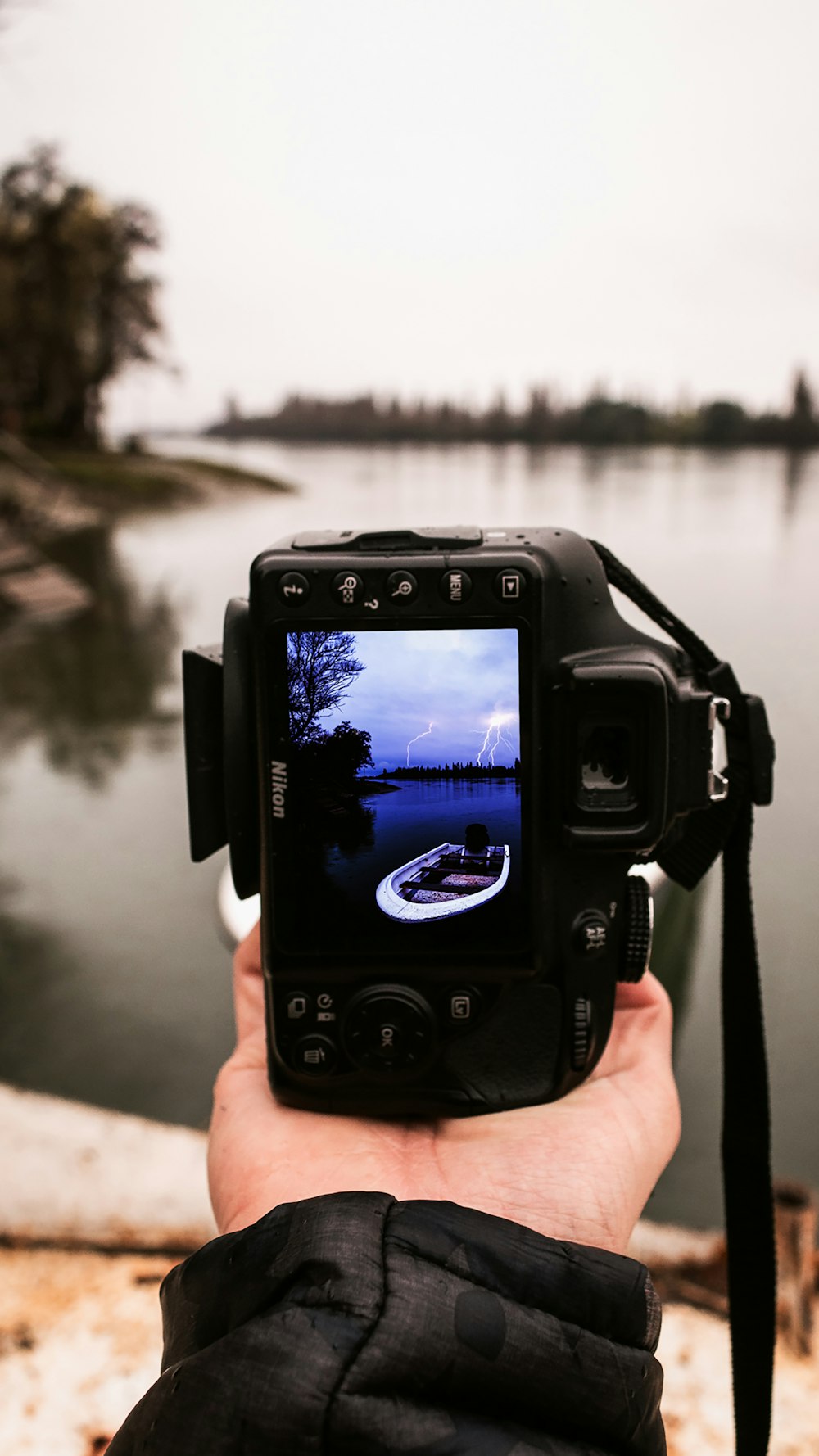 person holding black dslr camera taking photo of body of water during daytime