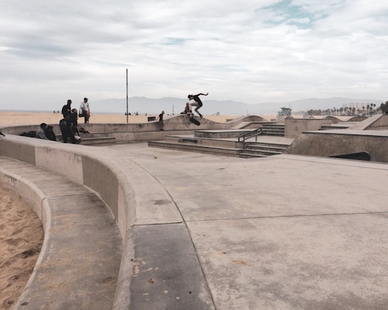 Young skateboarders practicing tricks at an outdoor skate park.