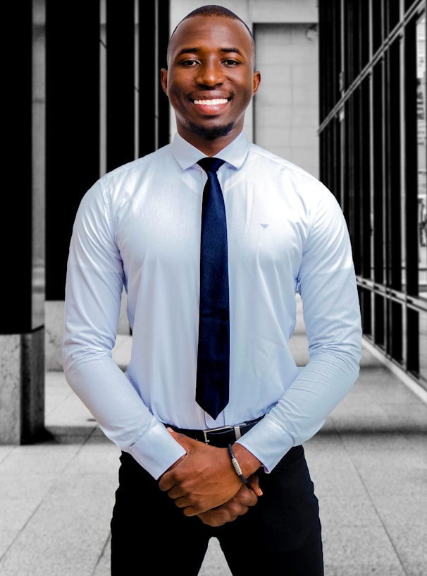 a man in a dress shirt and tie posing for a picture