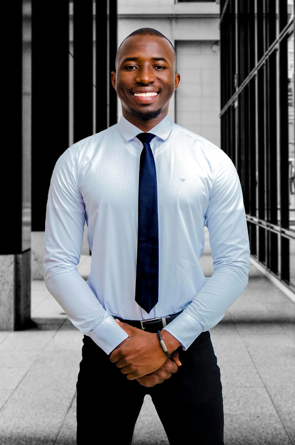 Un hombre con camisa de vestir y corbata posando para una foto