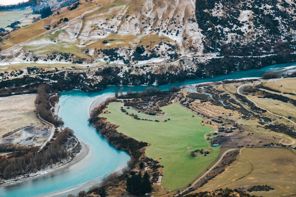 aerial view of green grass field near body of water during daytime