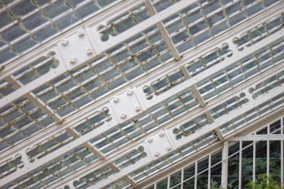 A close-up of architectural aluminum frames and glass panels at a trade show booth.