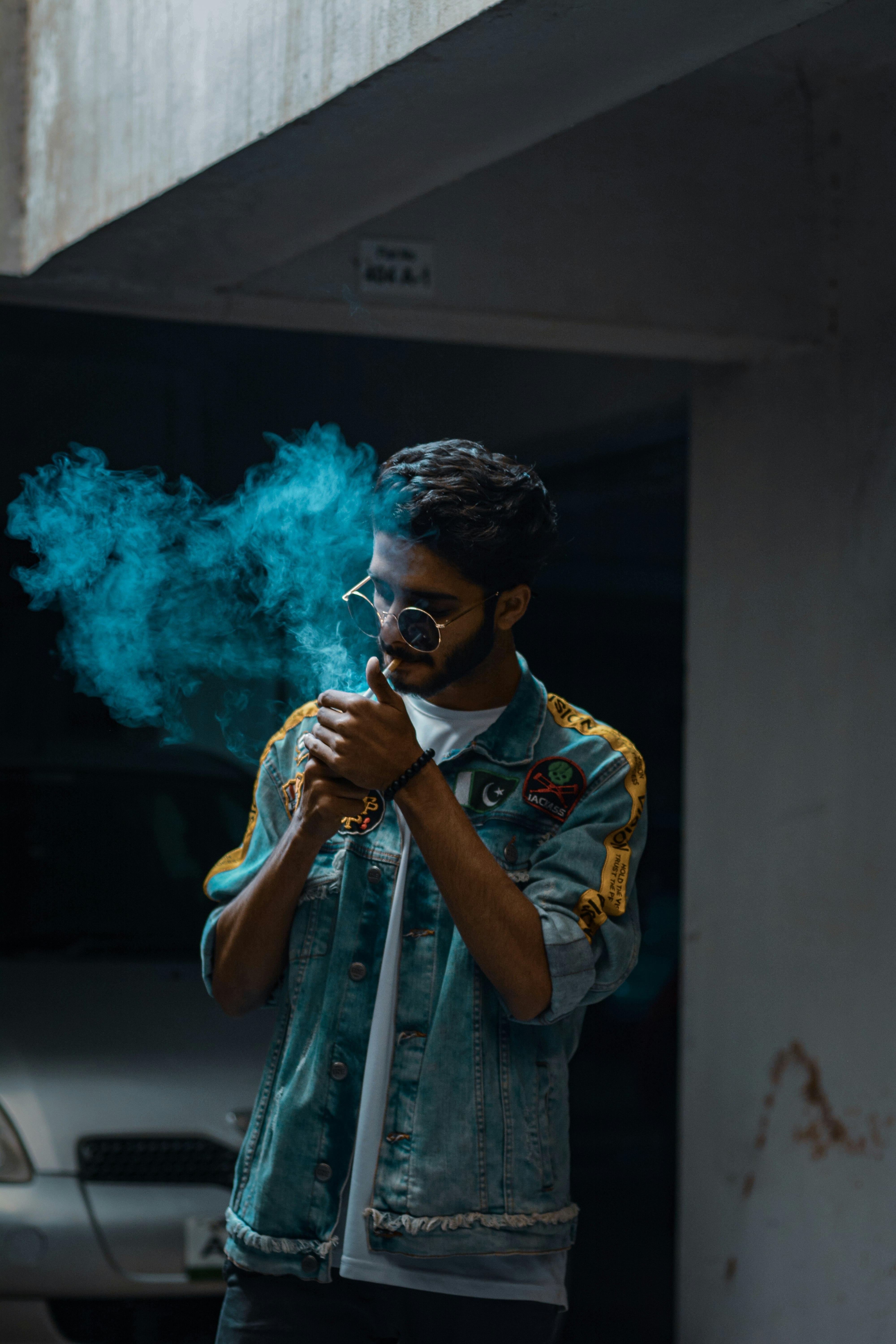 man in yellow and white crew neck shirt smoking cigarette