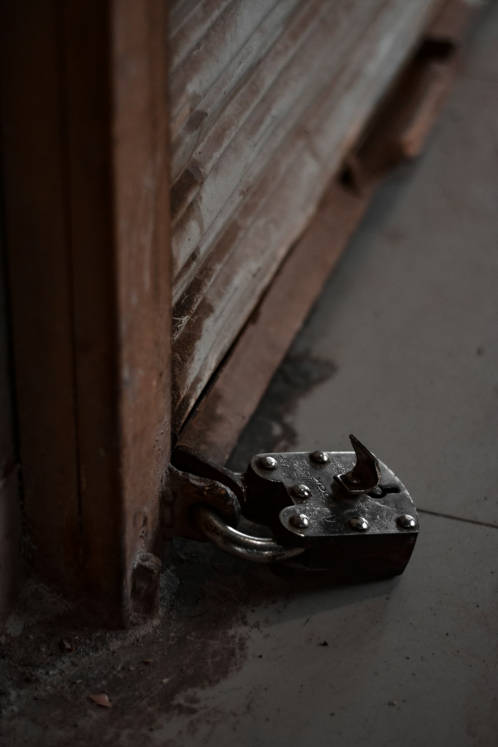 black metal padlock on grey concrete wall