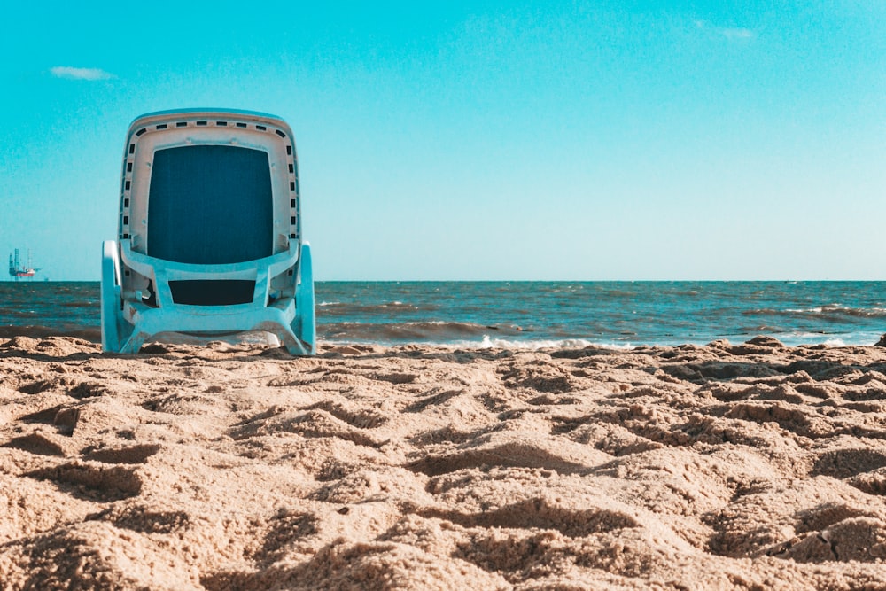 昼間のビーチの青と白のプラスチック製の椅子