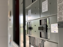 A close-up view of an industrial electrical panel with various switches and labels. The focus is on the switches, with the labels providing details about their use and installation instructions. The panel is metallic and has a utilitarian design.