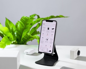 a cell phone sitting on a stand next to a keyboard