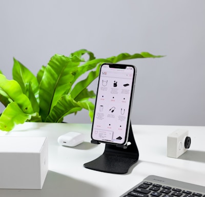 a cell phone sitting on a stand next to a keyboard