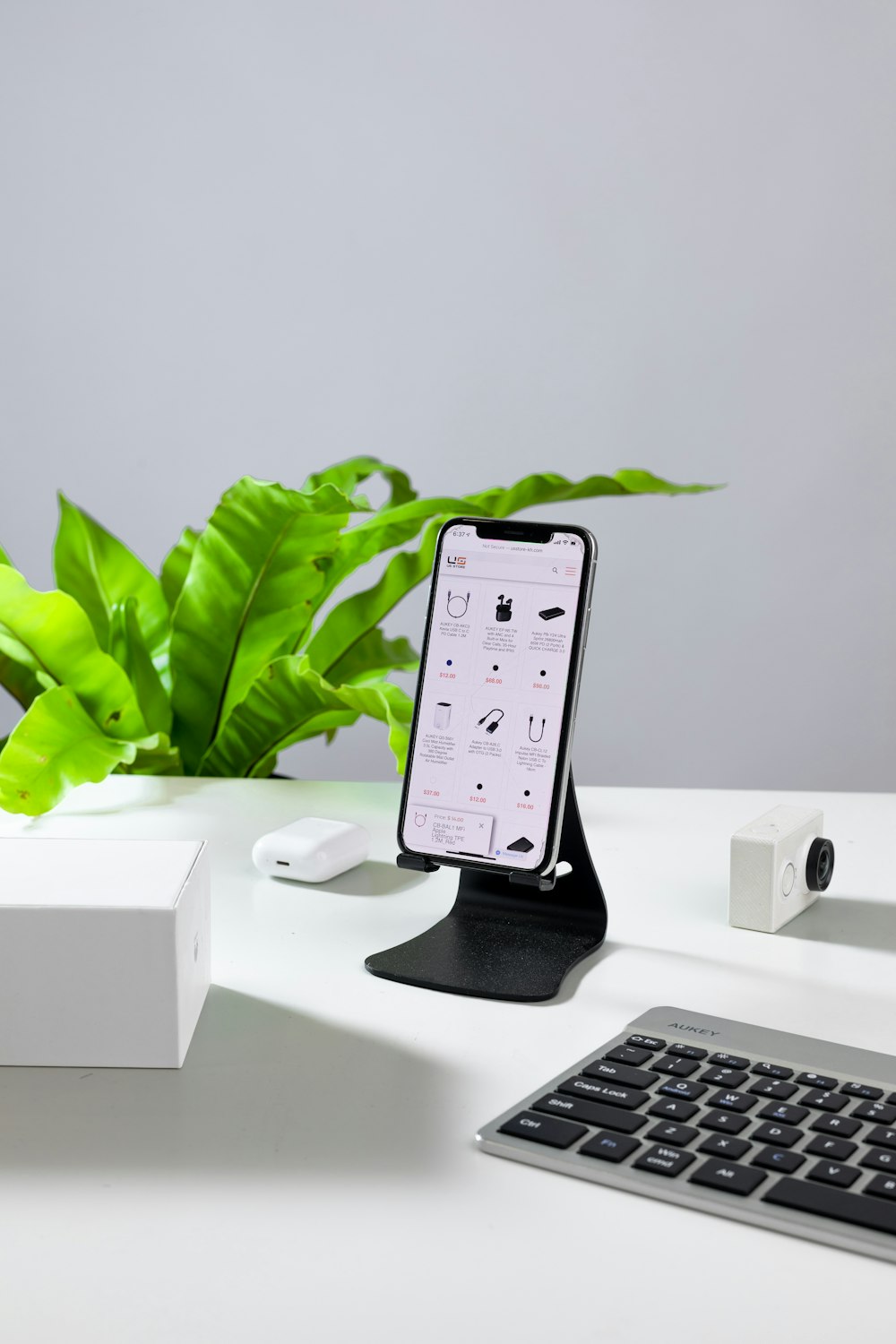 a cell phone sitting on a stand next to a keyboard