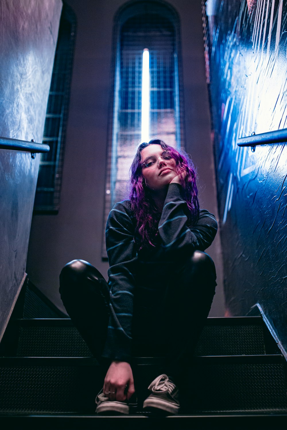 woman in black jacket and black pants sitting on window