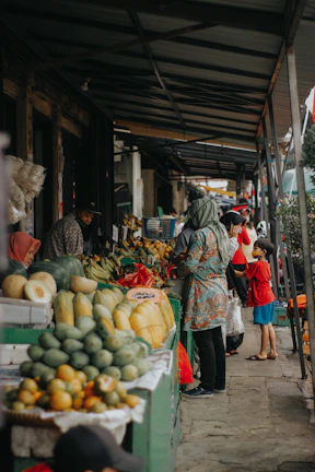 A lively market scene with fresh tropical fruits and smiling vendors.
