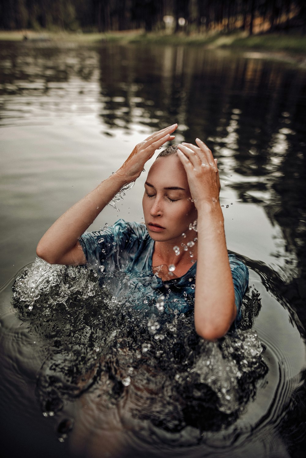 a woman in the water with her hands on her head