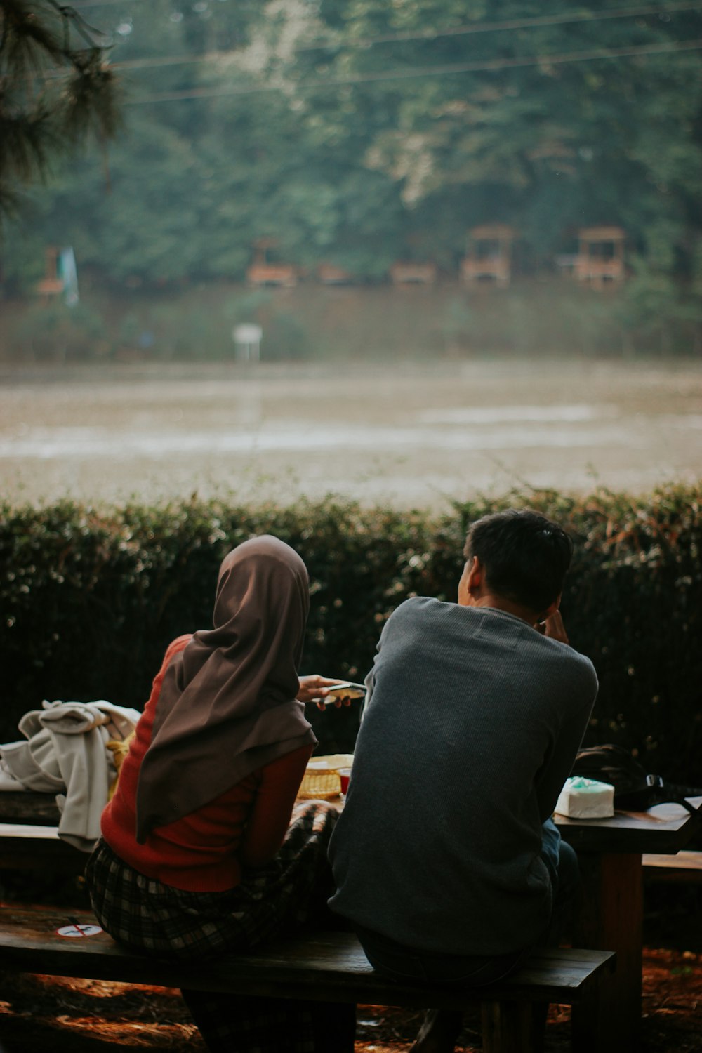 man and woman sitting on bench during daytime