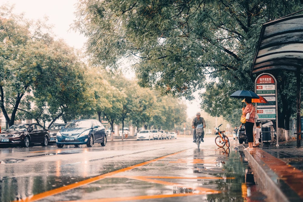 man in black jacket riding bicycle on road during daytime