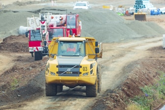 yellow and red heavy equipment on brown field during daytime