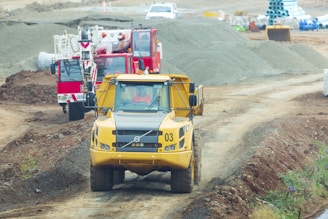 yellow and red heavy equipment on brown field during daytime