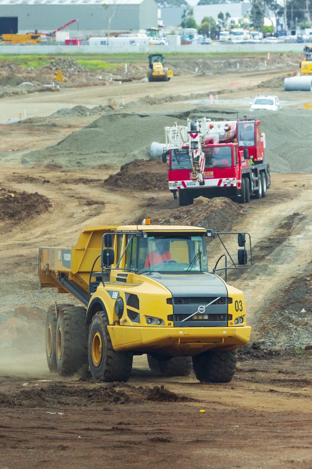 Gelber und roter LKW auf braunem Sand