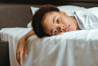 girl lying on white bed