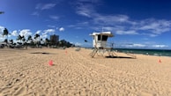 white and brown lifeguard house on beach during daytime