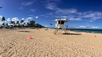 white and brown lifeguard house on beach during daytime
