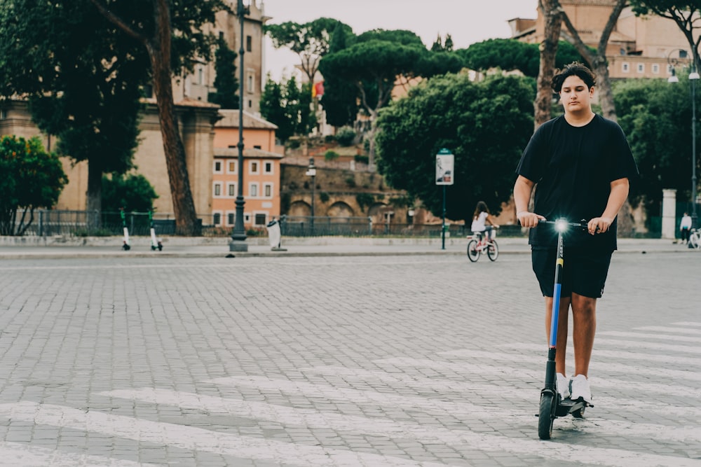 hombre con camisa negra y jeans de mezclilla azul montando en bicicleta