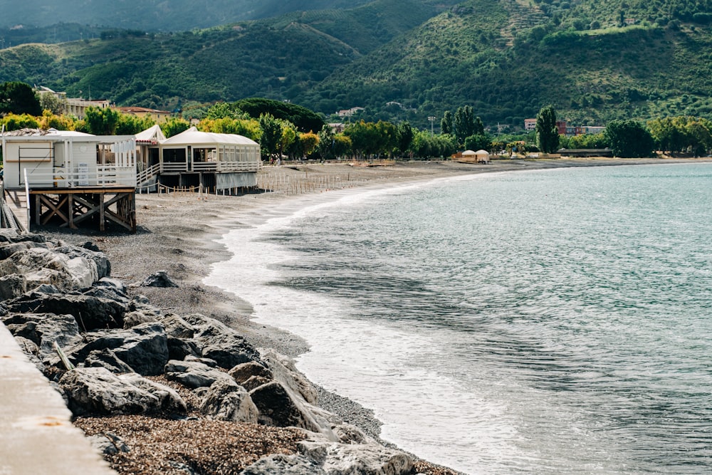 white and brown wooden house near body of water during daytime