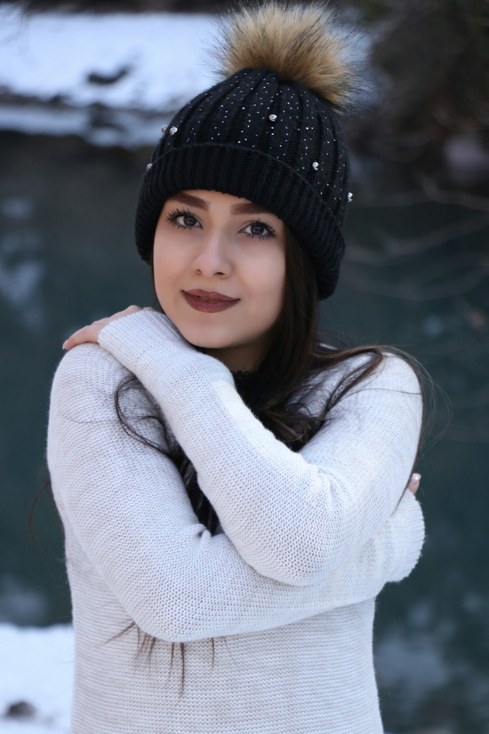 woman in white knit sweater and black knit cap