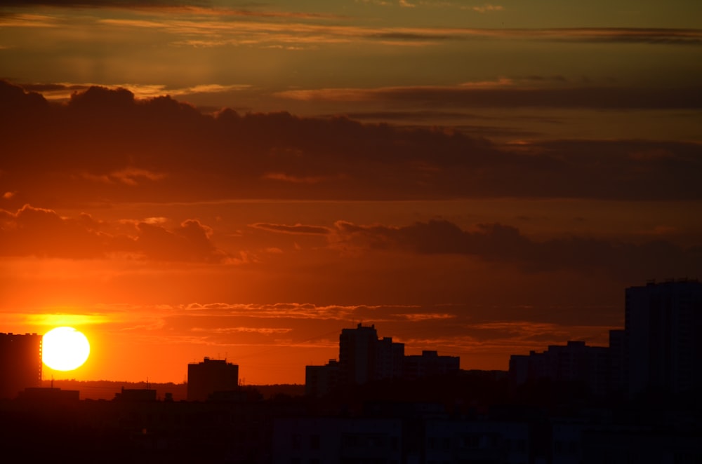 silhouette of city buildings under cloudy sky during daytime