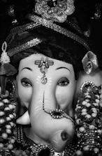 Close-up of a beautifully detailed eco-friendly Ganesh idol surrounded by natural leaves.
