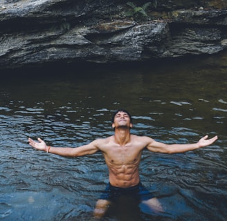 man in black shorts standing on water