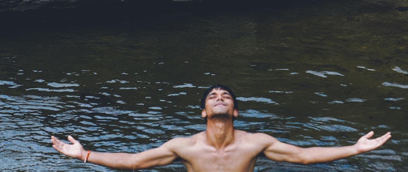 man in black shorts standing on water