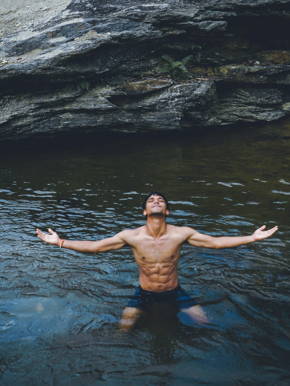 man in black shorts standing on water