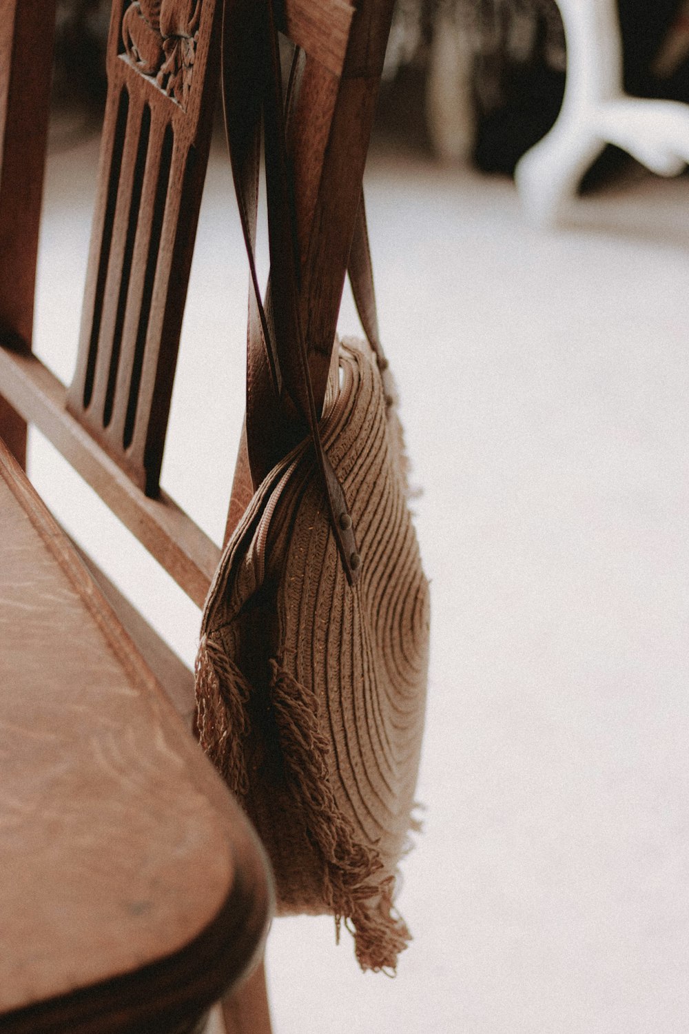 a close up of a wooden bench with a bag hanging from it