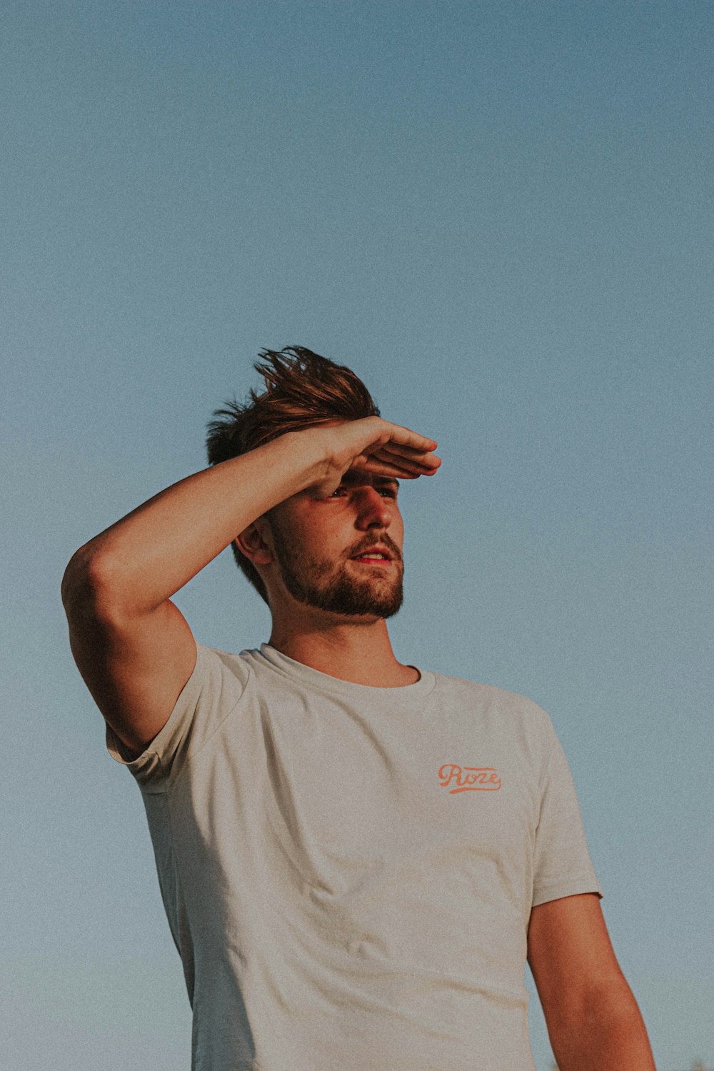 man in white crew neck t-shirt holding his head