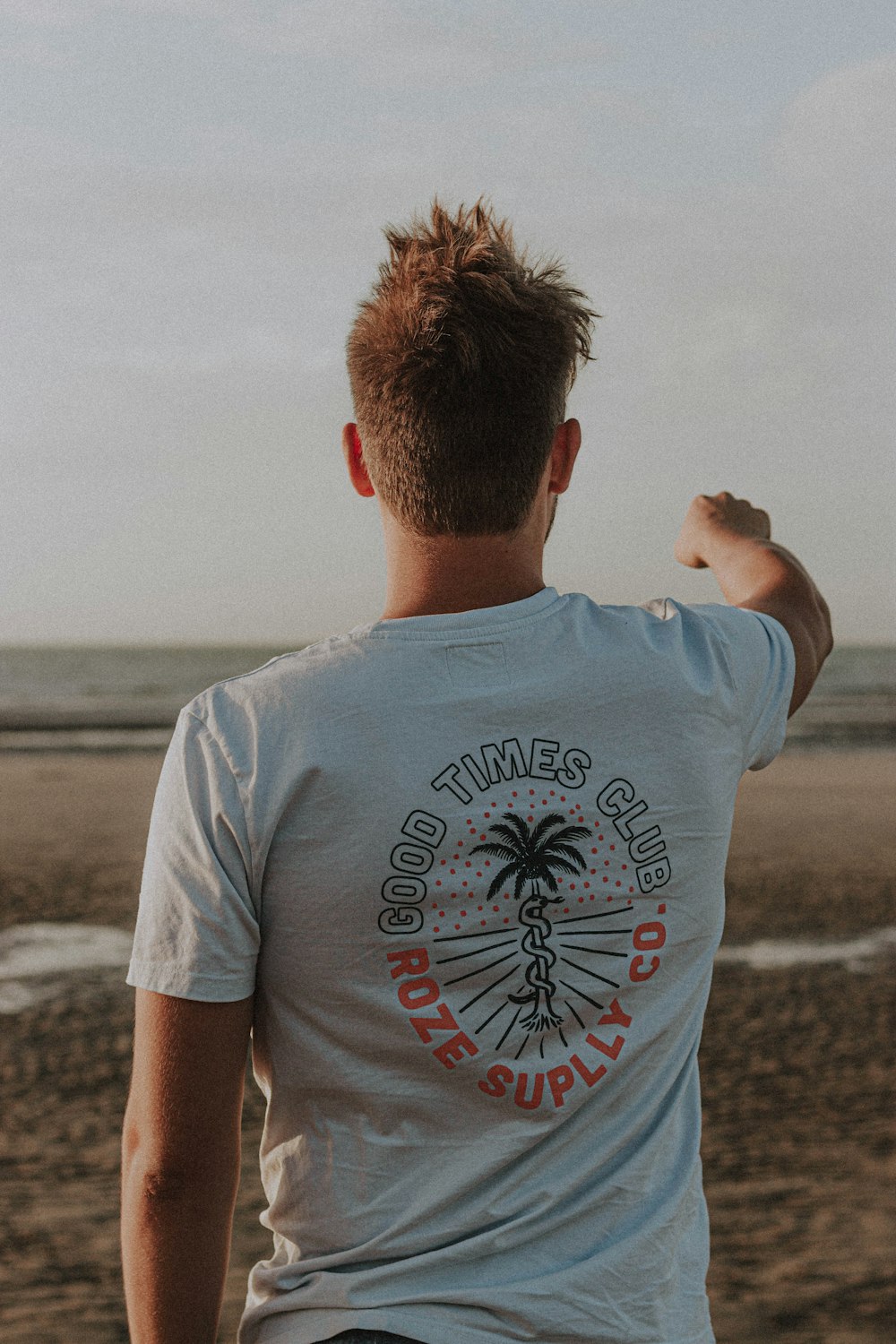 Mann im weißen Rundhals-T-Shirt tagsüber am Strand stehend