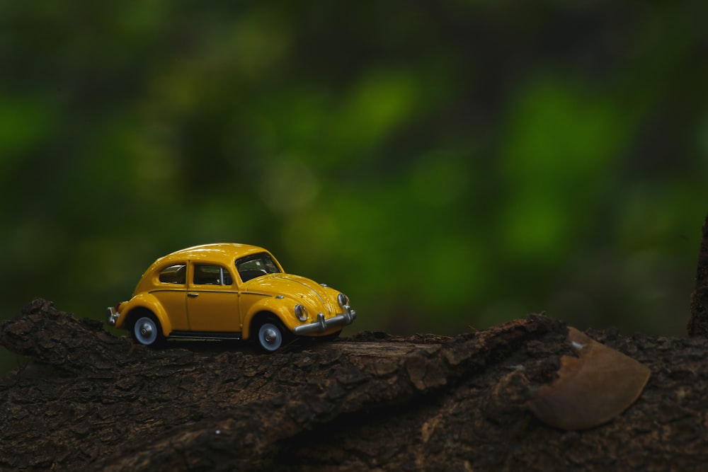 yellow coupe scale model on brown wooden surface