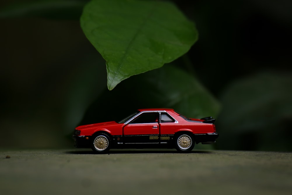 red coupe scale model on brown wooden table