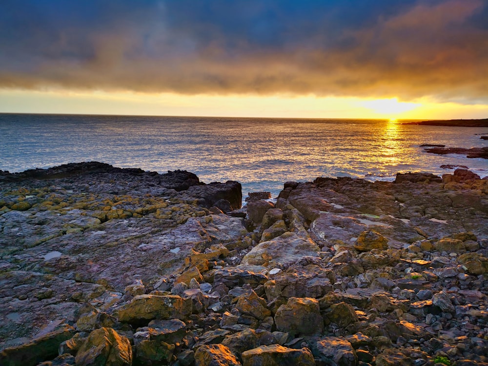 brown rocky shore during sunset
