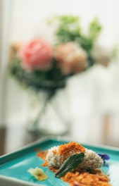 Close-up of a colorful gourmet dish garnished with fresh herbs on a rustic wooden table.