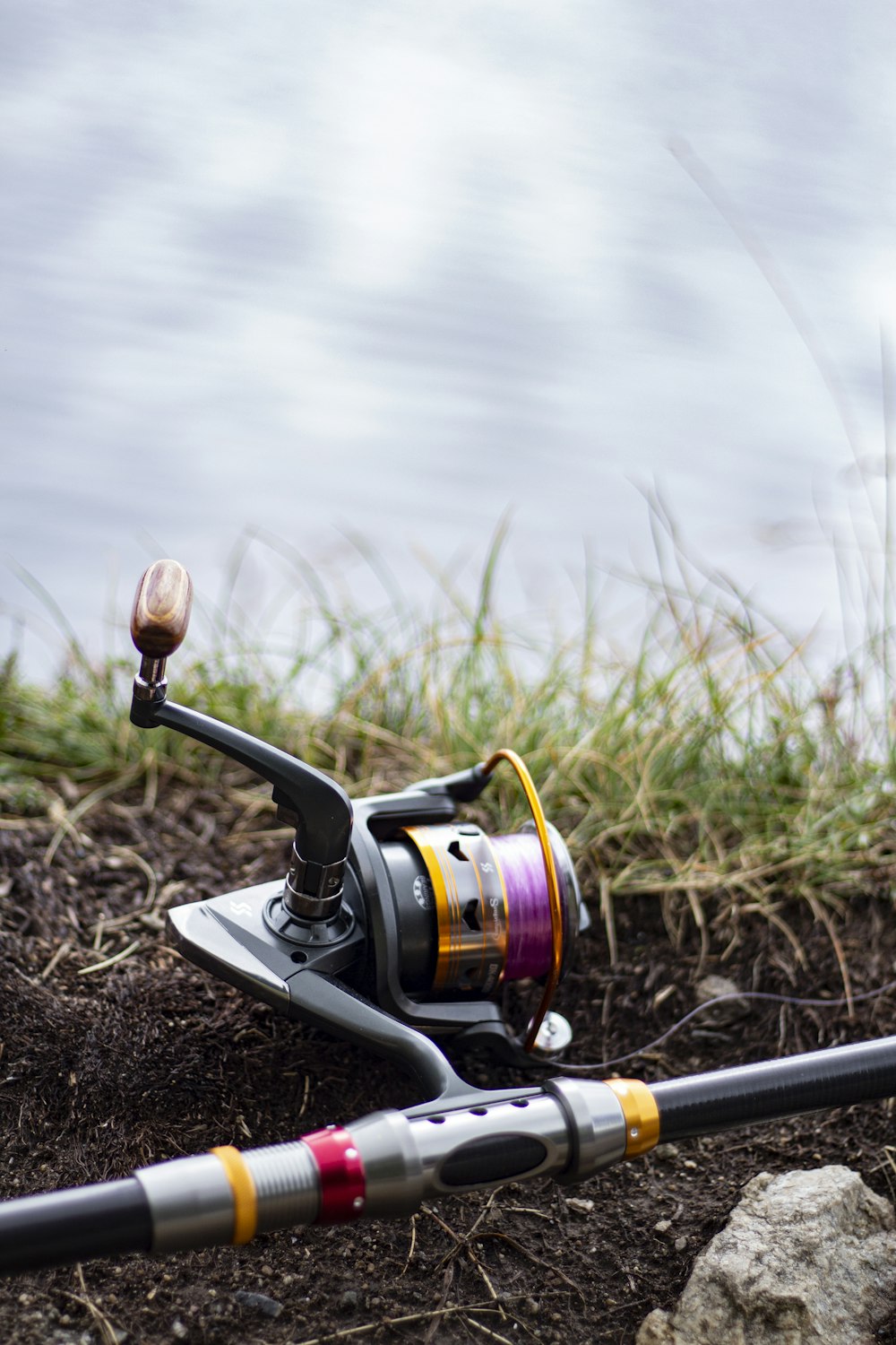 black and silver fishing reel on brown soil