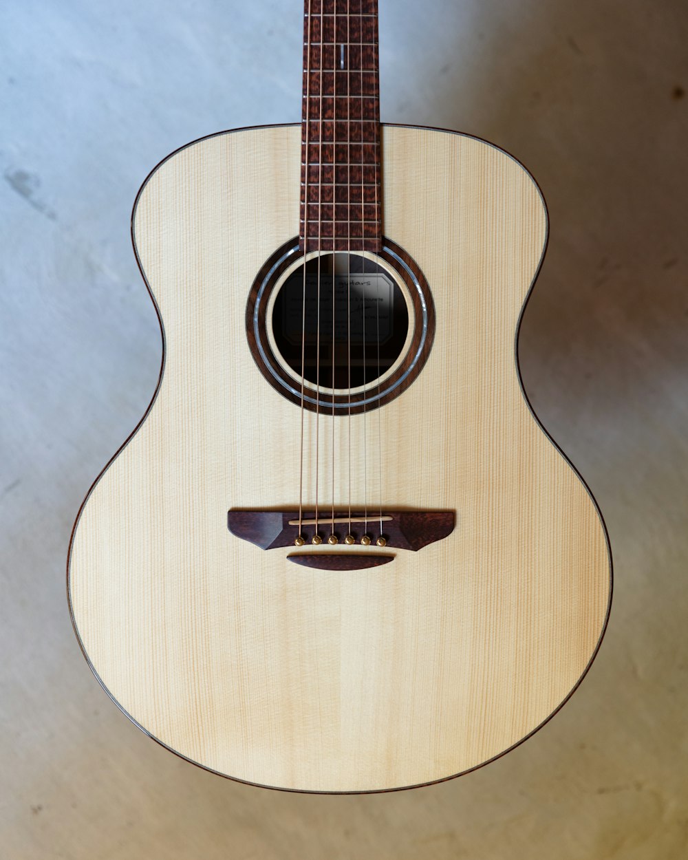 brown acoustic guitar on blue textile