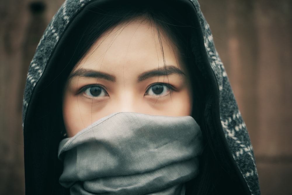 woman covering her face with gray and black hijab