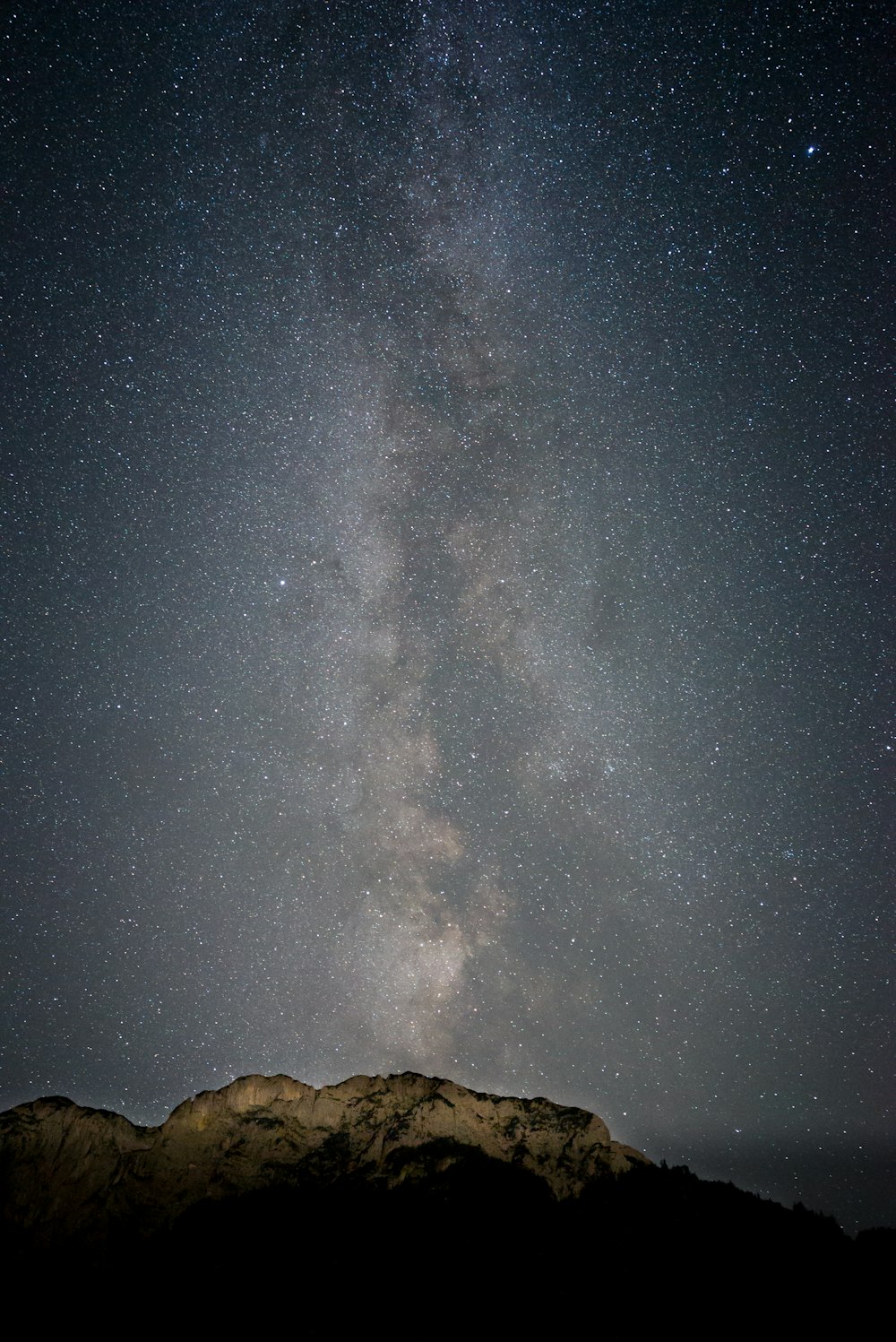 Montagna rocciosa marrone sotto la notte stellata