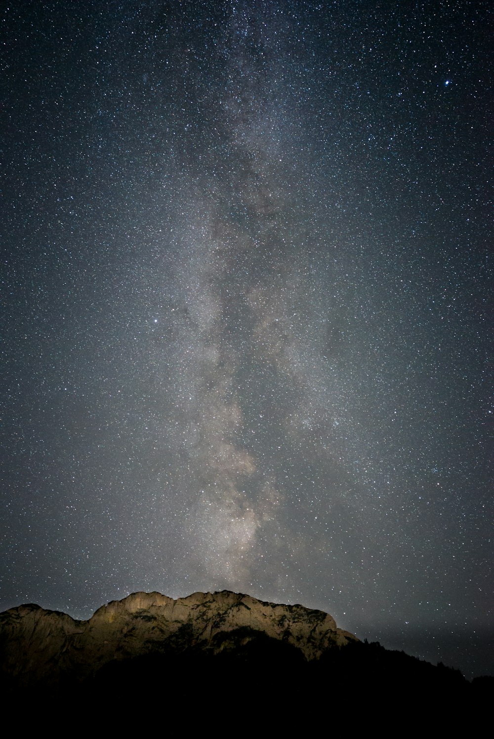 montanha rochosa marrom sob a noite estrelada