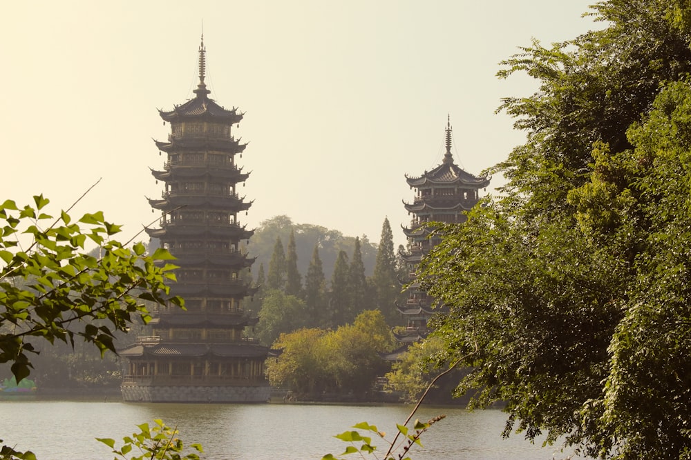 brown temple near green trees and river during daytime