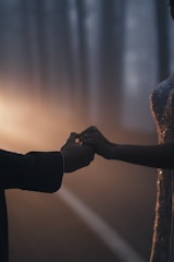 A quiet moment of a couple holding hands, framed by soft shadows.