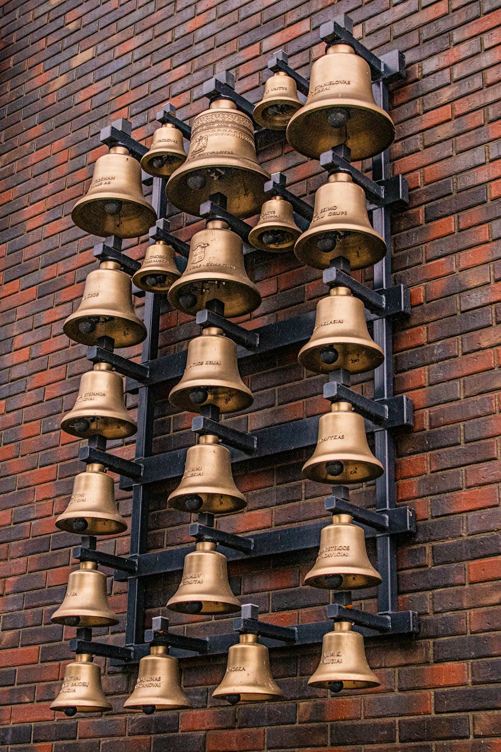 brass bell on brown brick wall